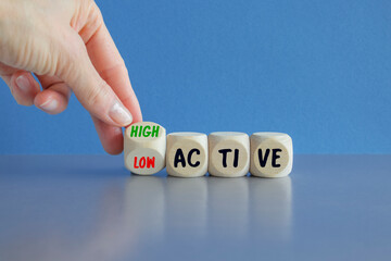 High or low active symbol. Businessman hand turns a cube and changes the word High active to low...