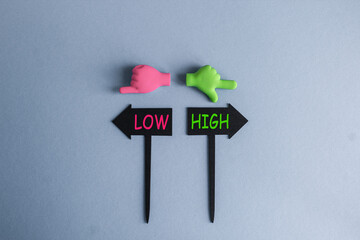 High or low symbol. BLACK ARROW-SHAPED PLAQUES WITH THE WORDS High or low. HANDS POINTING IN...