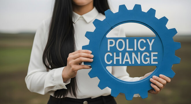 Woman holding blue gear with policy change text in front of blurred background on transparent background