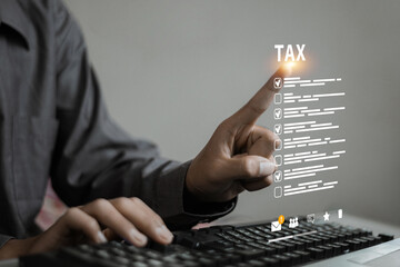 Person using keyboard pointing at digital tax checklist on virtual screen