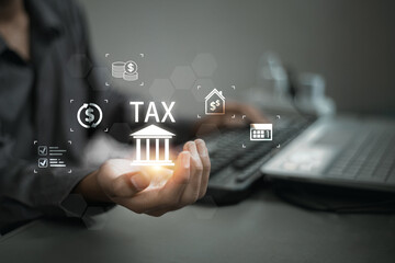 Person’s hand holding glowing digital bank icon with the word TAX and other financial symbols floating above it