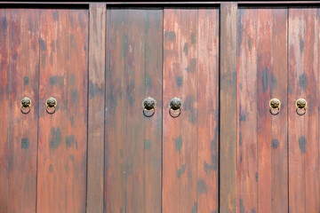 Traditional Chinese wooden doors with lion head knockers of a heritage building in George Town, Penang, Malaysia.