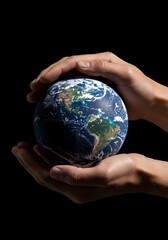 Hands cradling a globe showing north and south america against a black background in studio shot
