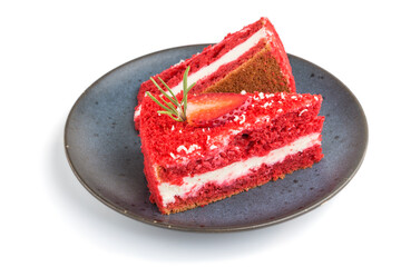 Homemade red velvet cake with milk cream and strawberry on blue ceramic plate isolated on white...