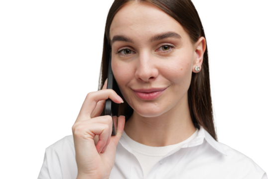 Engaging conversation with a friendly smile from a young woman using a smartphone in a bright, empty background
