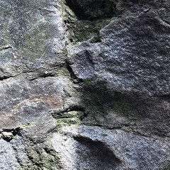 Natural Stone Surface with Shadow and Light Border in Close-up Showing Texture and Moss Details