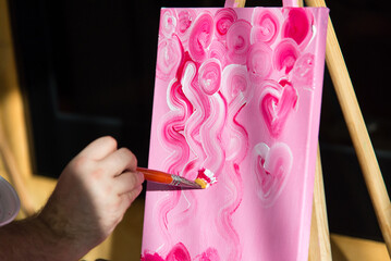 artist painting a picture on canvas, close-up of a person's hand holding a brush, creative process	