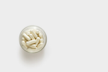 Capsules pills in glass bowl on white background