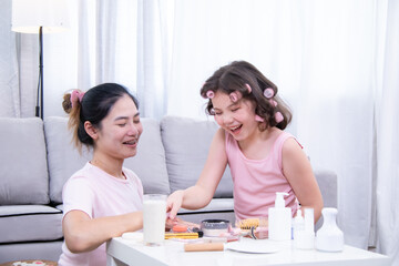 Obraz premium Kids, cosmetic, child, beauty, skincare, A girl and her mother laugh together while playing with makeup items, showing fun, love, and joyful bonding in a family selfcare moment at home