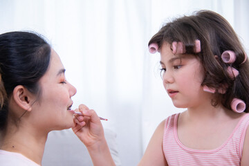 Kids, cosmetic, child, beauty, makeup, A girl with hair curlers applies makeup on her mother's...
