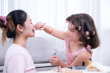 Kids, cosmetic, child, beauty, makeup, A girl with hair curlers applies makeup on her mother's...
