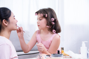 Kids, cosmetic, child, beauty, makeup, A girl with hair curlers applies makeup on her mother's...