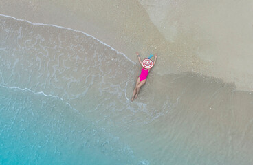 Aerial view of summer with young woman relaxation  sunbath as lying on the beach  in Maldives
