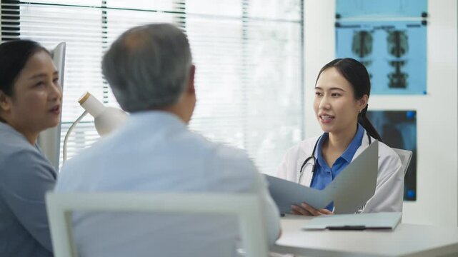 Asian doctor in uniform attentively assists a senior couple with medical paperwork in a hospital area, explaining health records and test results with care and professionalis senior health	
