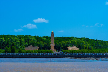Obraz premium National coordinate monument at Ca Mau Cape, the southernmost point of Vietnam, surrounded by mangrove forest and muddy estuary.