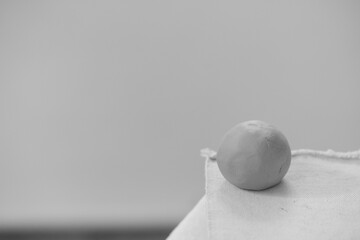 Round clay ball for pottery and sculpting on a blurred background. Raw ceramic material