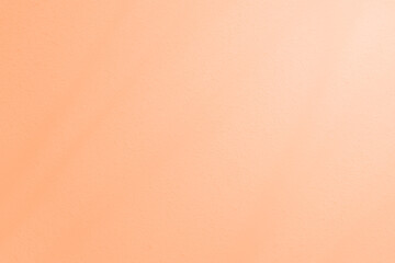 peach fuzz warm cement wall texture background. with shadow lights of tree on wall