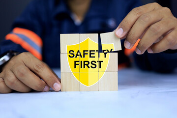 Safety first in workplace and hazard prevention concept with supervisor arrange wooden block for safety shield icon to encourage staff beware at all time