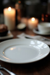 Elegant white ceramic plate on dark wooden table with soft candlelight ambiance
