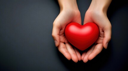 Obraz premium Love and Care: Hands Cradling Red Heart on Dark Grey Top view photo of holding