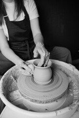 Potter shaping a ceramic artwork on a wheel. Hands in clay. Artistic pottery workshop