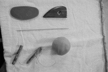 Round clay lump and ceramic hobby tools set on rustic table for pottery crafting