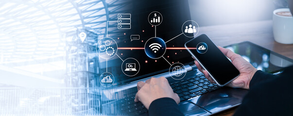 Businessman Hand Using Smartphone and Laptop with Technology Icon Overlay, Digital Connection Concept for Innovation, Cloud Computing, Wireless Network, and Modern Communication Background