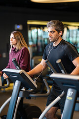 A man running on a treadmill at the gym.