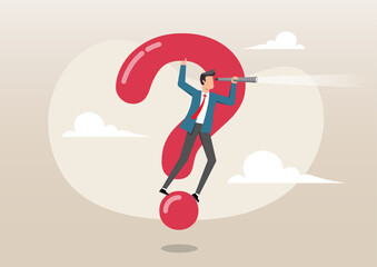 A businessman in a suit standing and balancing atop a large, red question mark