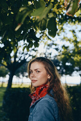 Lifestyle woman in modern boho-western denim street style with a red bandana, natural light, and...
