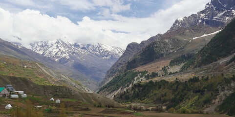 panorama of beautiful valley surrounded by snowcapped himalaya mountains, birds eye view of...