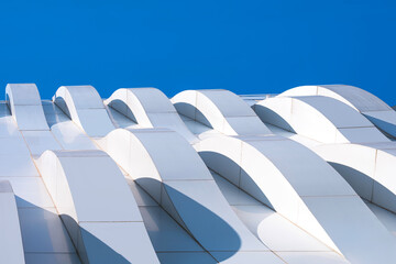 Building Modern Exterior Architecture Decoration Design, 3d Dimension Curve Pattern of Geometric White Aluminum Composite Tile Wall against Blue Sky Background, View from Below