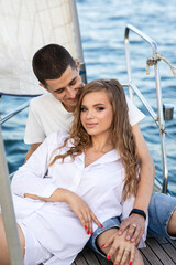 Beautiful young couple in love on a yacht at sea in summer