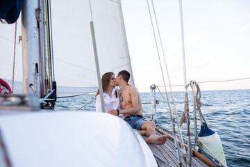 Beautiful young couple in love on a yacht at sea in summer