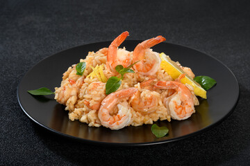 Delicious Shrimp Risotto with Sicilian Lemon Garnish on a Black Plate