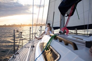 Beautiful young couple in love on a yacht at sea in summer