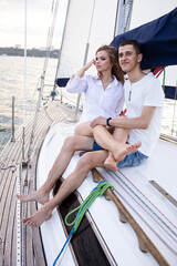 Beautiful young couple in love on a yacht at sea in summer