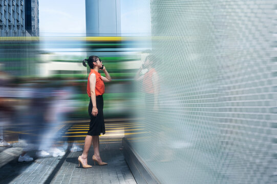 Woman using phone and walking on the street