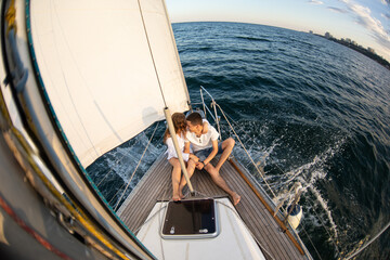 Beautiful young couple in love on a yacht at sea in summer