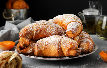 Freshly Baked Apricot Jam Croissants with Powdered Sugar – Cozy Tea Time Setting
