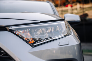 Close-up of car headlights of a new car. Automotive leasing and insurance. Automotive industry. The...