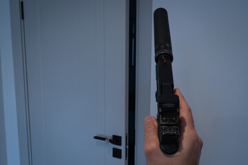 First-person view: a man with a silenced pistol in his hand prepares to enter the room. Thriller or...