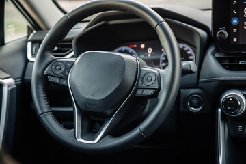 Close-up of a car steering wheel in a modern new car. The interior of a stylish new car. Concept of...
