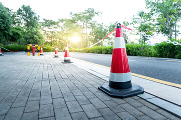 Cone barricade between pedestrian walkway and highway