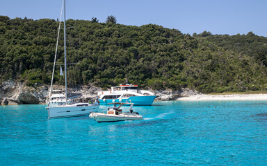 Obraz premium boats on clear turquoise water near forested island beach