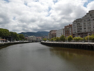 Fototapeta premium Vista del río Nervión cruzando un puente con edificios de Bilbao al fondo