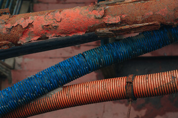 Rusty Pipe and Colored Corrugated Conduit Close-Up