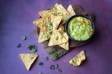 Traditional Mexican snack of nacho tortilla chips paired with guacamole.