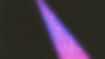 Light leak with purple and pink gradient colors on dark textured background film grain