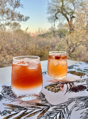 two glasses of old fashion with a soft light sunset background